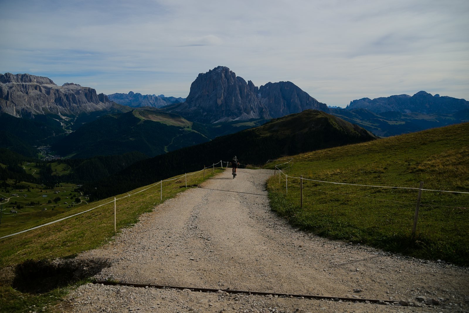 Chemin de gravier menant vers des sommets montagneux sous un ciel dégagé