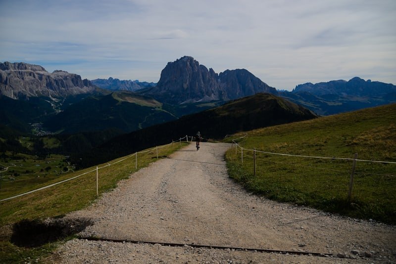 Chemin de gravier menant vers des sommets montagneux sous un ciel dégagé