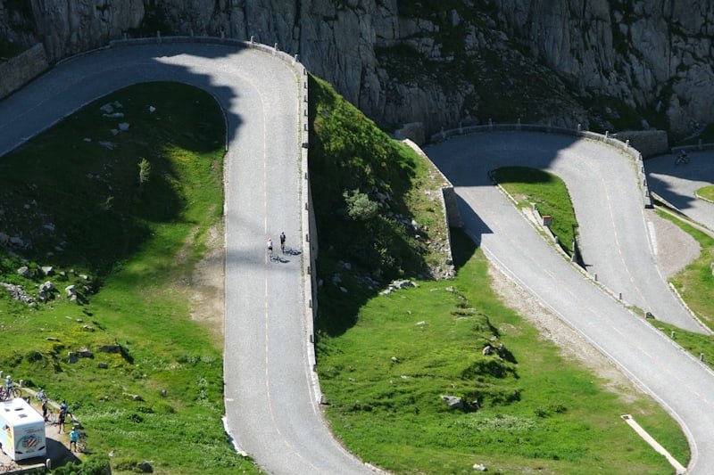 Route de montagne en lacets serpentant sur des pentes verdoyantes