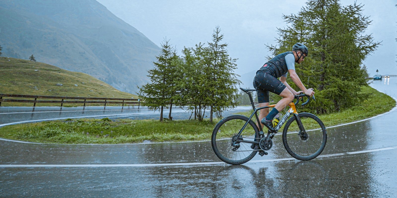 Cycliste roulant sur une route détrempée par la pluie