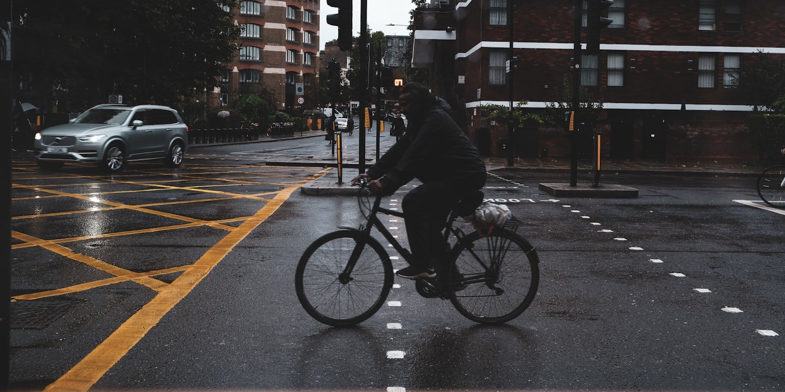 Cycliste circulant sur une piste cyclable urbaine sous la pluie